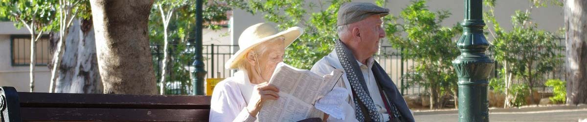 Ein altes Ehepaar sonnt sich auf einer Parkbank